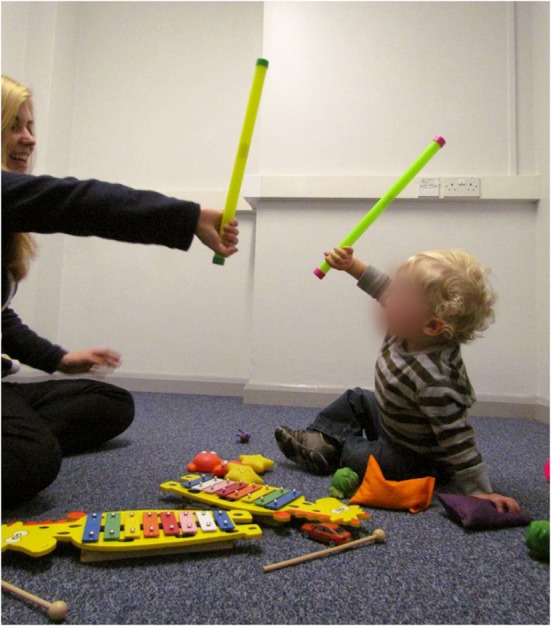 Niño y terapeuta durante una sesión Reciprocal Imitation Training (RIT). RIT implica que el terapeuta imita las acciones y gestos del niño, así como el modelado de las acciones y gestos apropiadas para el desarrollo de la imitación, en un contexto de juego. El niño se anima a imitar, hasta que se establece la imitación recíproca espontánea regular.